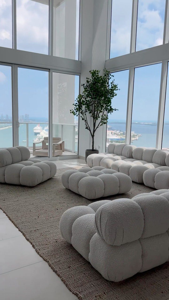 White modular bubble sofas and ottoman in a bright living room with city views.