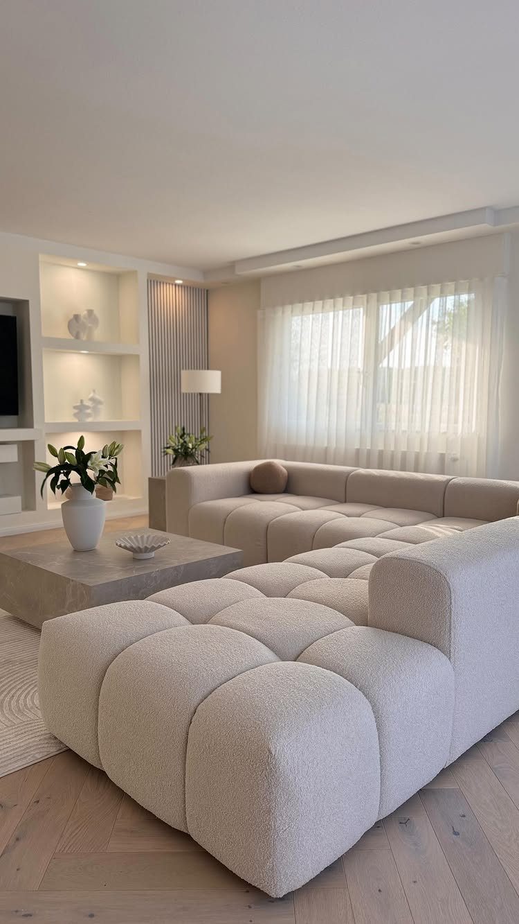 Two matching beige modular sofas in a modern living room with a stone coffee table.