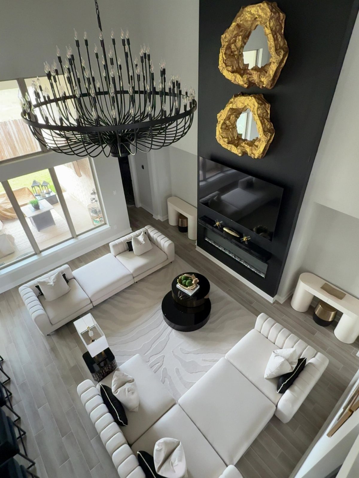 Three white tufted sofas arranged in a U-shape around a black coffee table