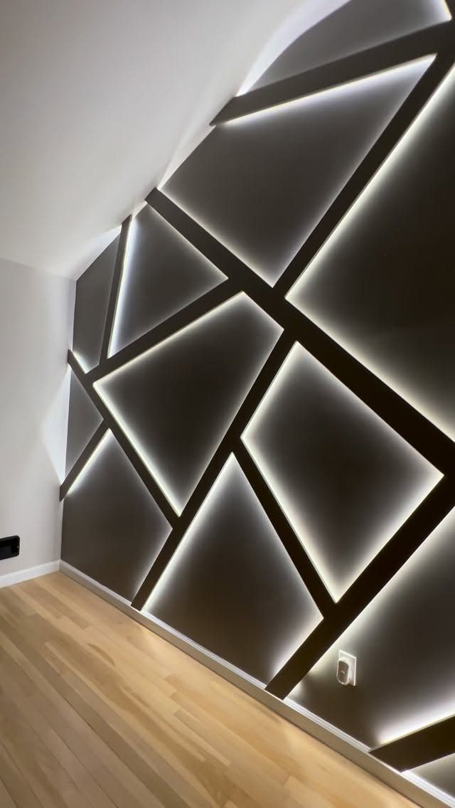 Geometric wall design with black beams and white LED backlighting in a living room