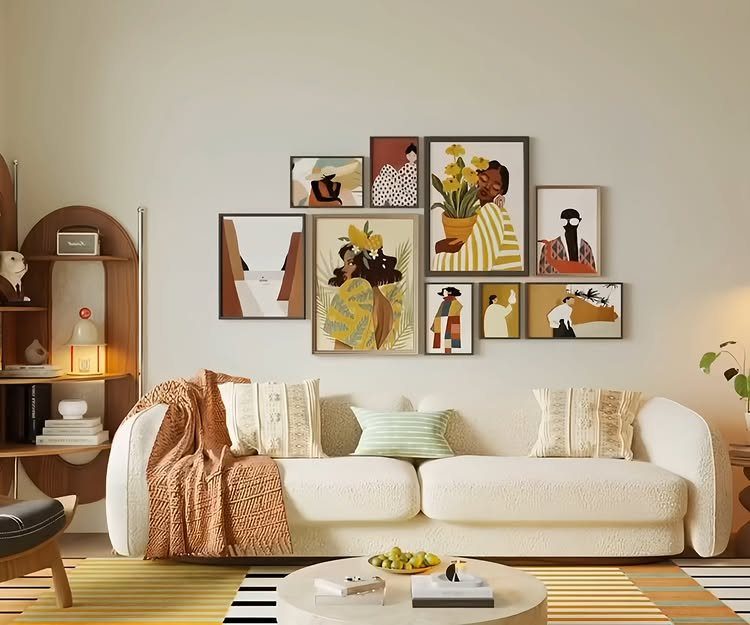 Gallery wall of abstract framed art above a white sofa in a living room