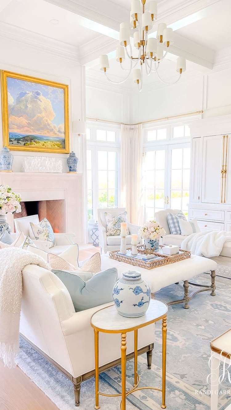 White living room with light blue accent pillows on elegant white armchairs