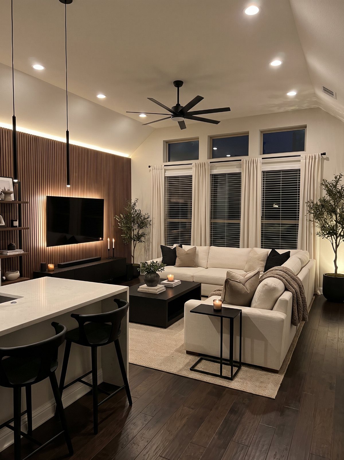 Modern white living room featuring contrasting black furniture and dark hardwood floors.